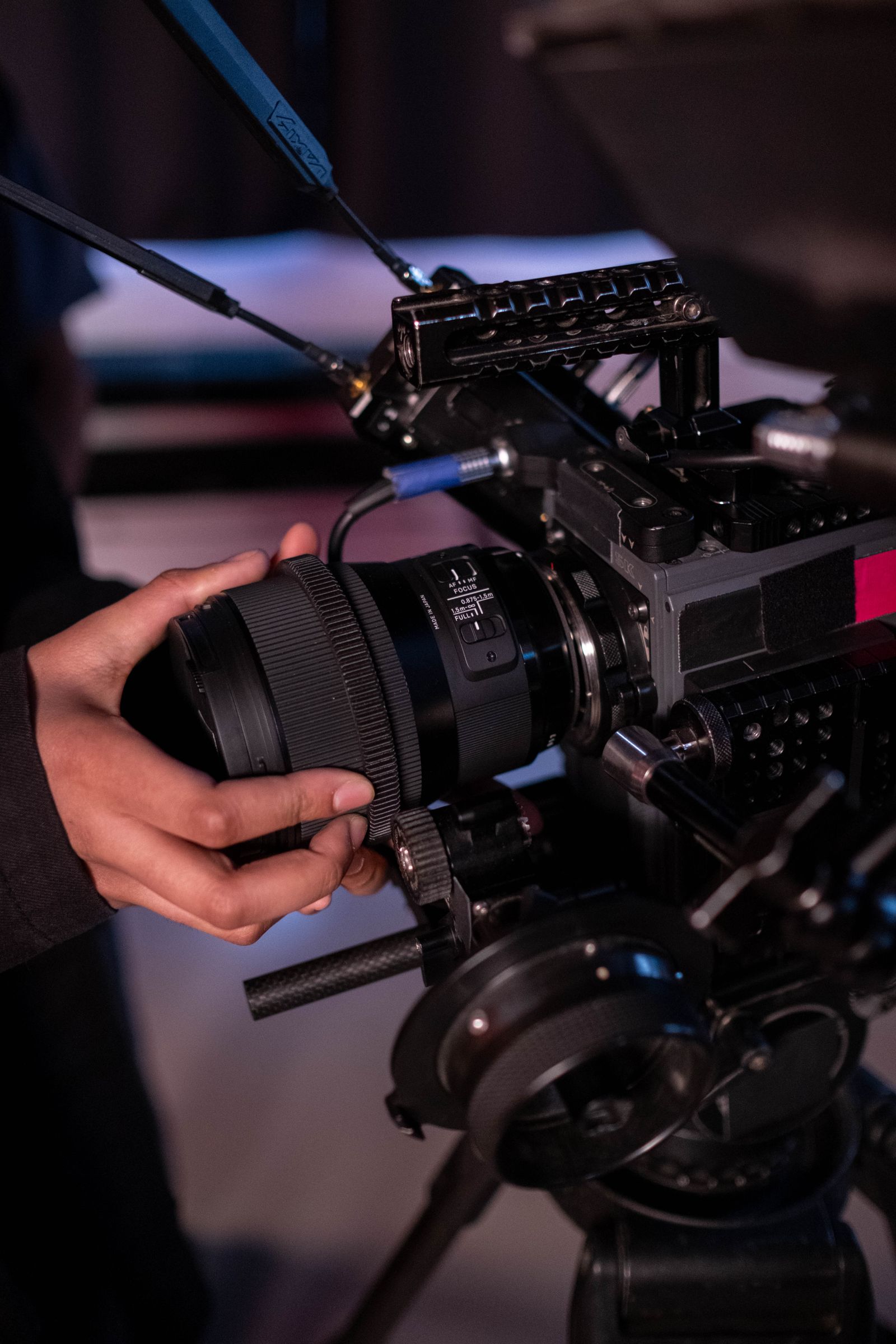Hands adjusting a cinema camera lens in natural light