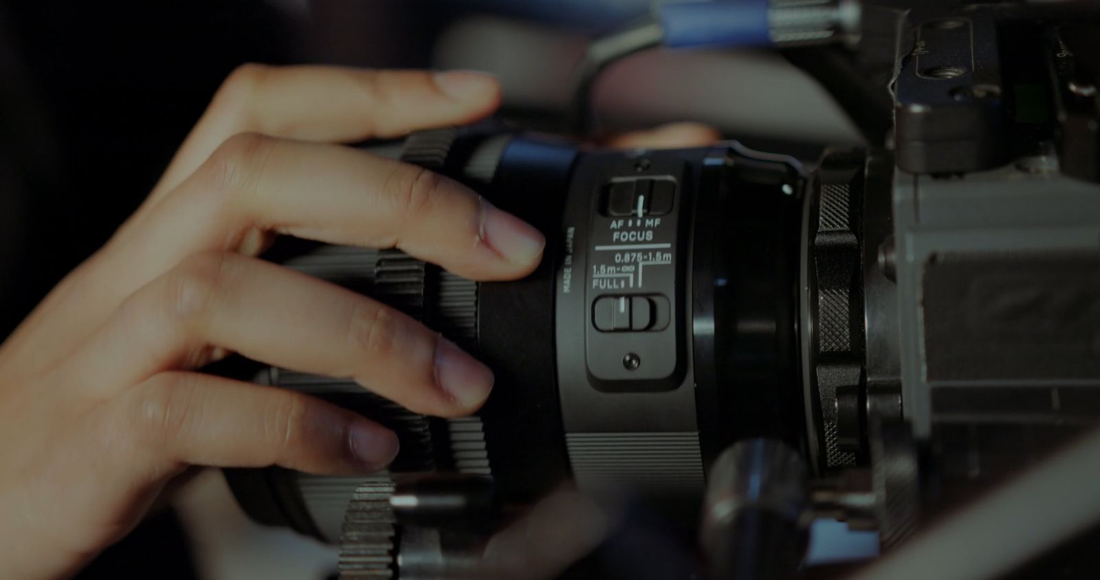 Hands adjusting a cinema lens during production