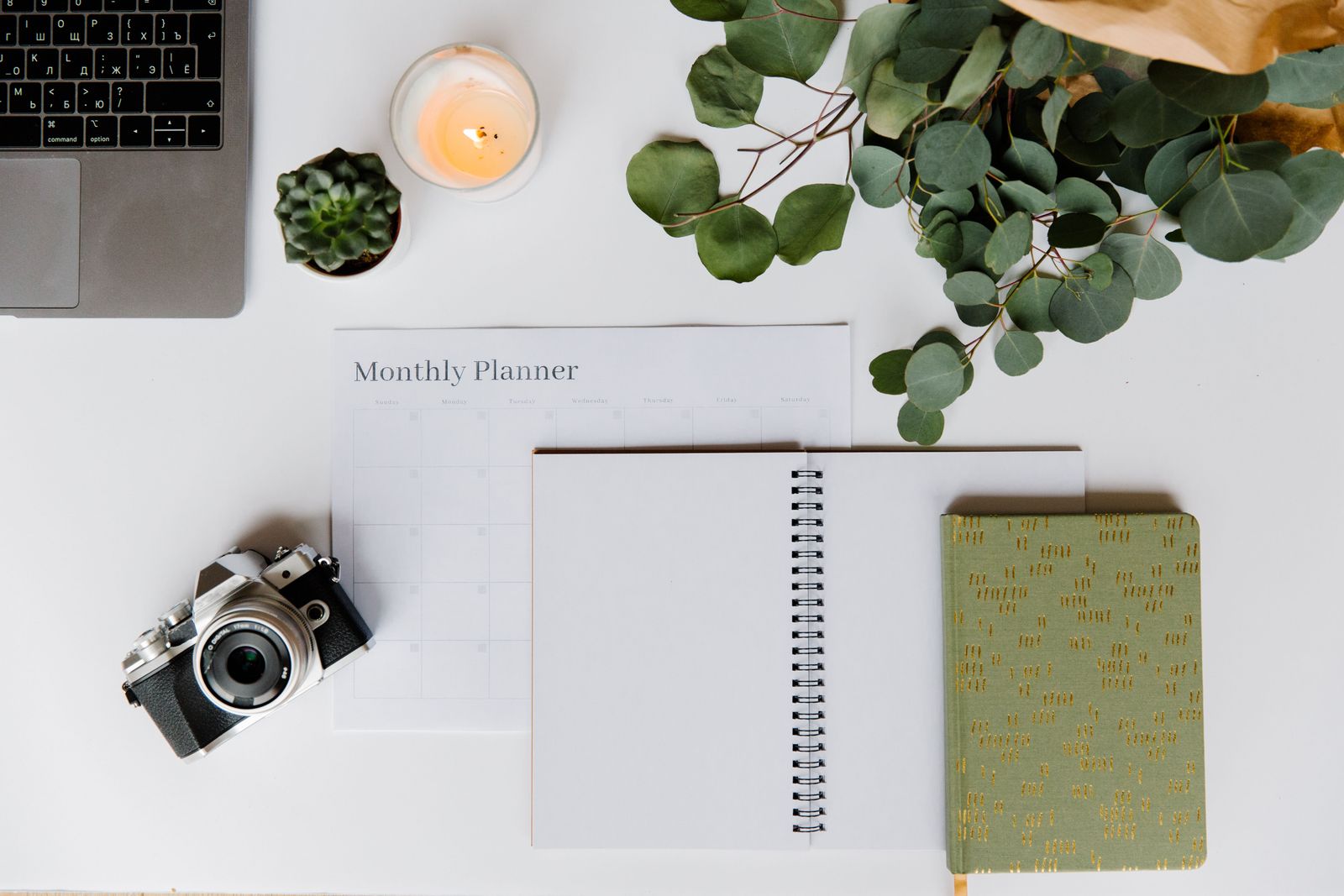 Camera, notebook and creative tools arranged on a worktable